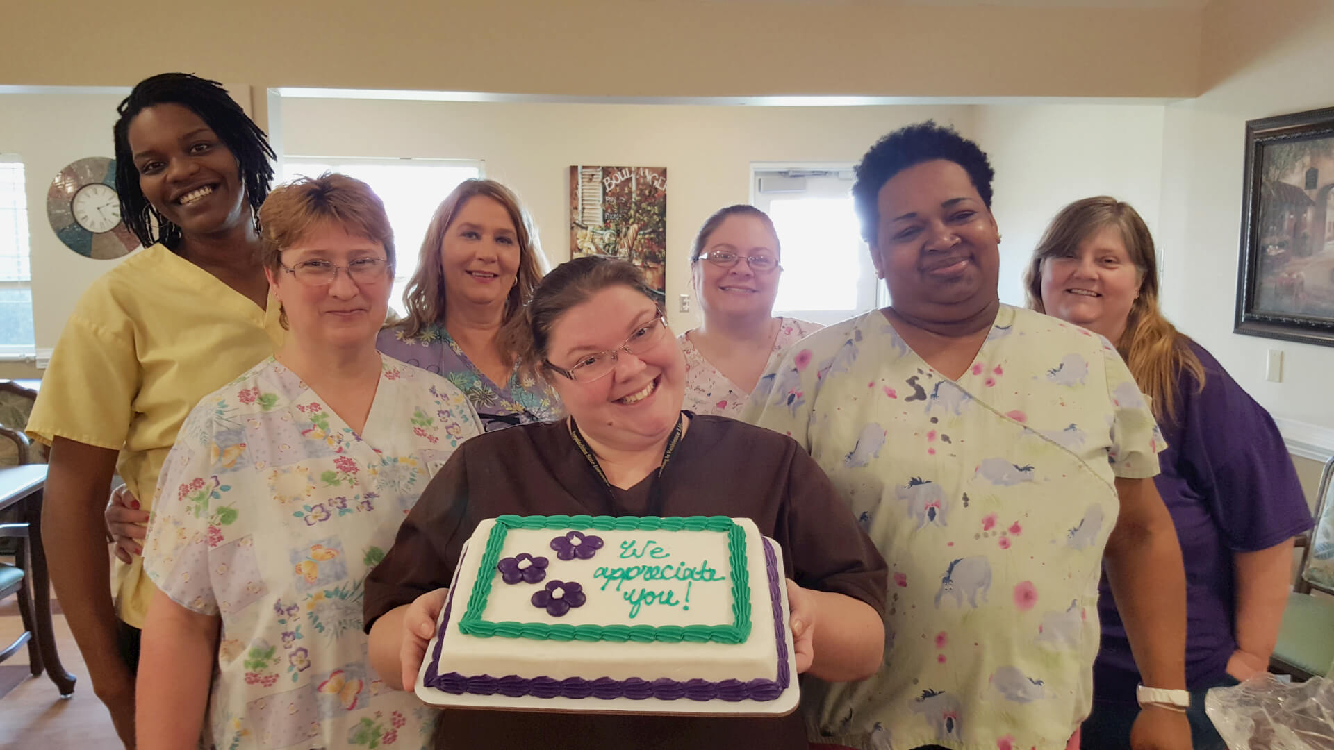 Hickory Village employees holding the cake given to them by residents in honor of Employee Appreciation day