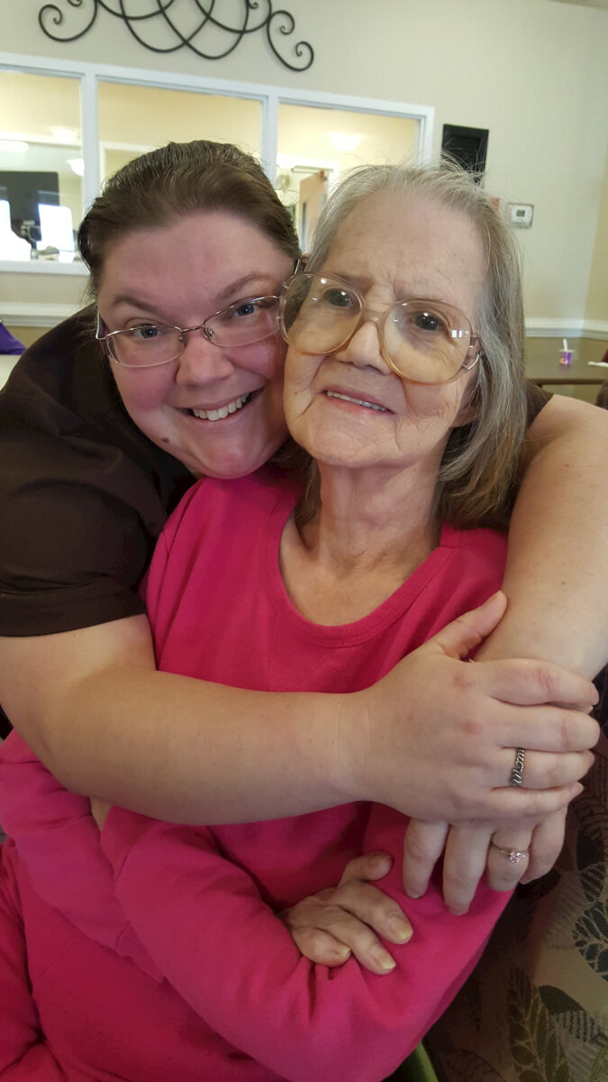 resident Wilma Kendall gives Personal Care Assistant Tina Merritt a hug.