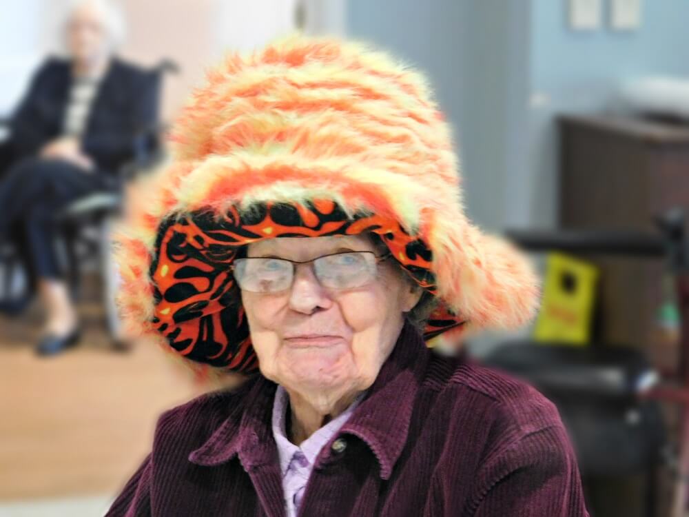 Westwood Commons resident Florence VanCott wearing a furry orange hat for national hat day