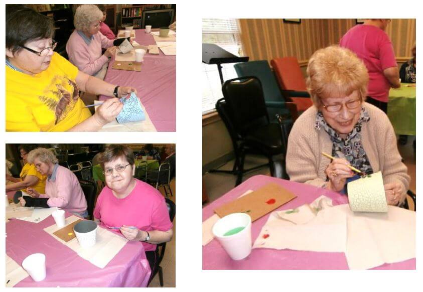 Twelve Oaks residents hand painting flower pots with spring colors
