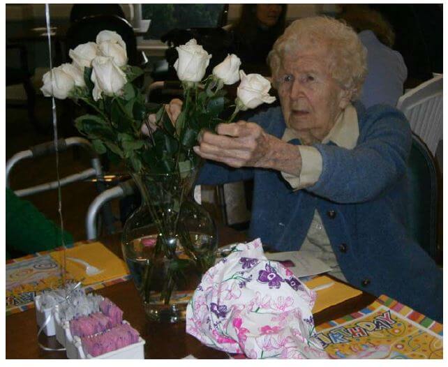 Glenwell resident Florence Raczynski adjusting white roses in a vase
