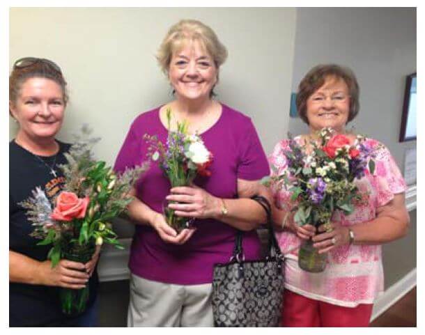  Palmetto Street Church of God Parishioners Joan Taylor, Barbara Matthews and Betty Freeman holding the flowers to be delivered