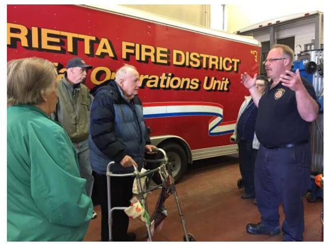 Residents listen to a Henrietta firefighter talk about some of the equipment