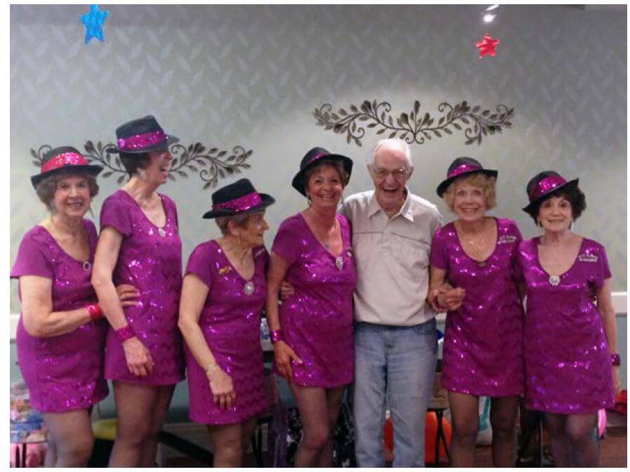 Hot Flash Tap Dancers posing with Woodcrest Commons resident Fred Recchio.