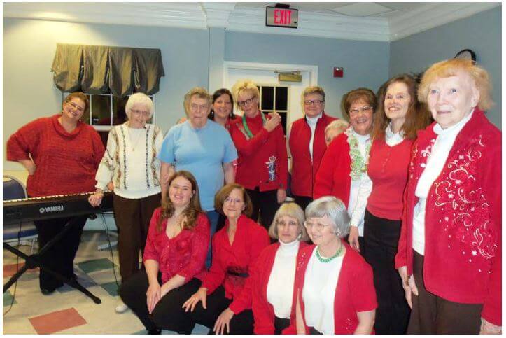 For Singing’s Sake members posing with residents of Westwood Commons