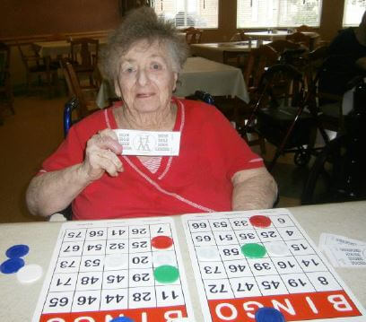 Wexford House resident Joan Conway shows off the “Wexford Bucks” she earned participating in a recent game of bingo.