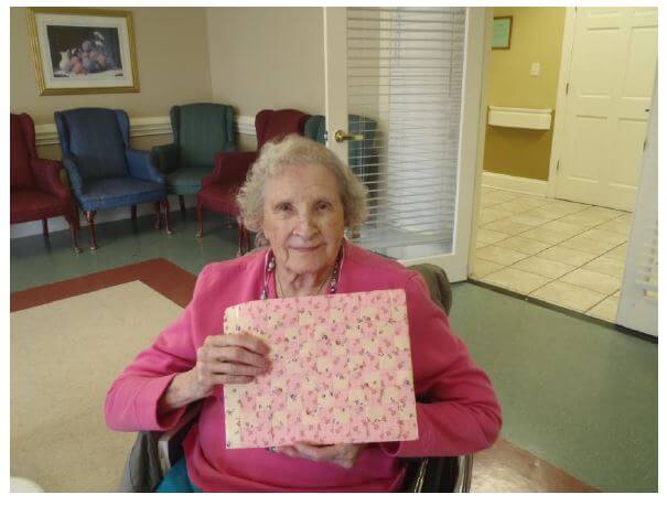 Willyne Sanders, a 99-year-old resident at Woodridge, shows off the completed weaving project. 