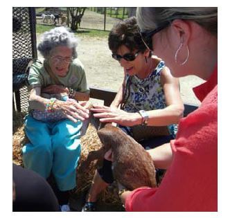 Woodridge Assisted Living residents petting the zoo animals