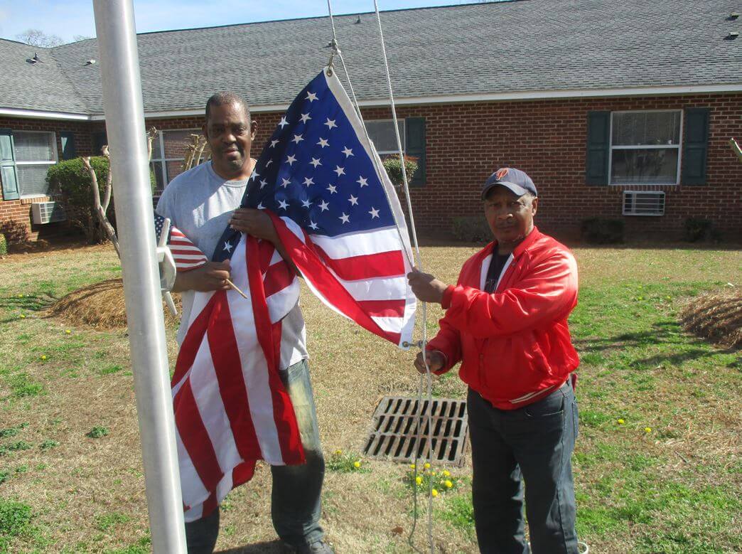 Jima. Residents Tommy Hall and Larry Scott are seen here saluting Old Glory.