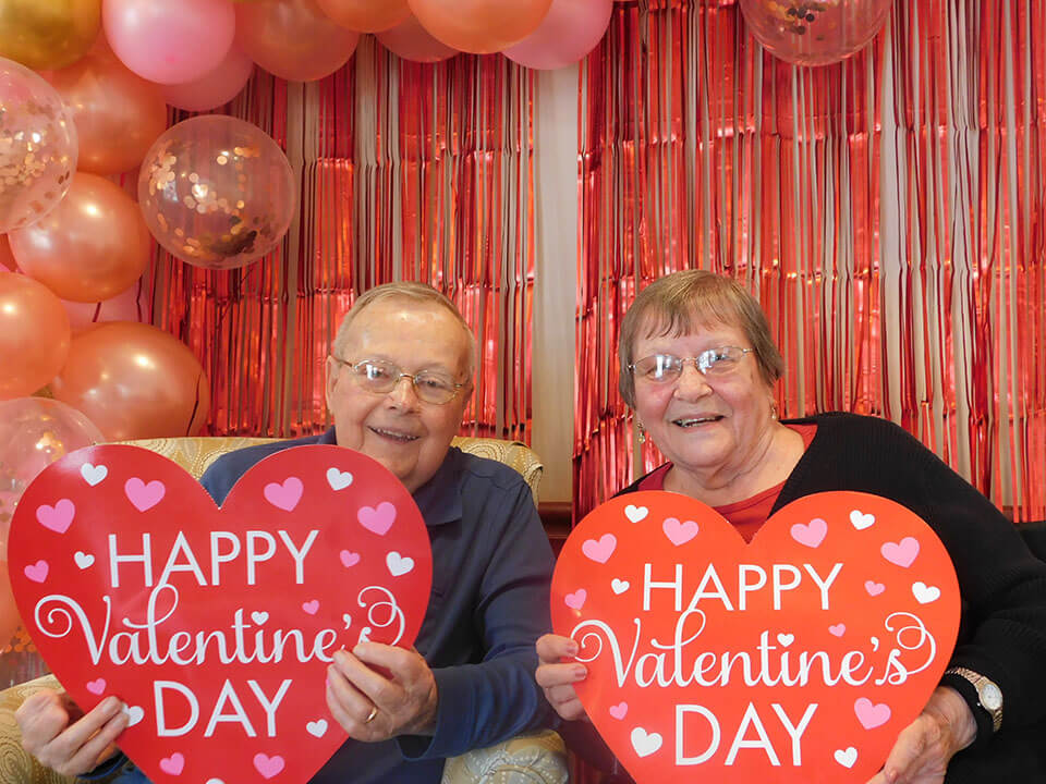 Senior couple posing with Valentine's Day decor